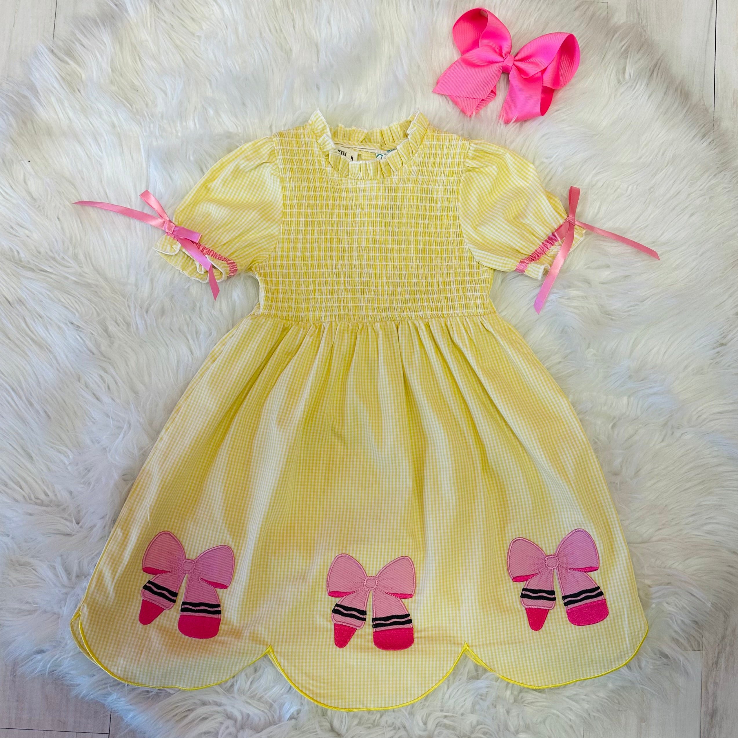 Girl’s yellow and pink crayon with pink ribbons on sleeve dress