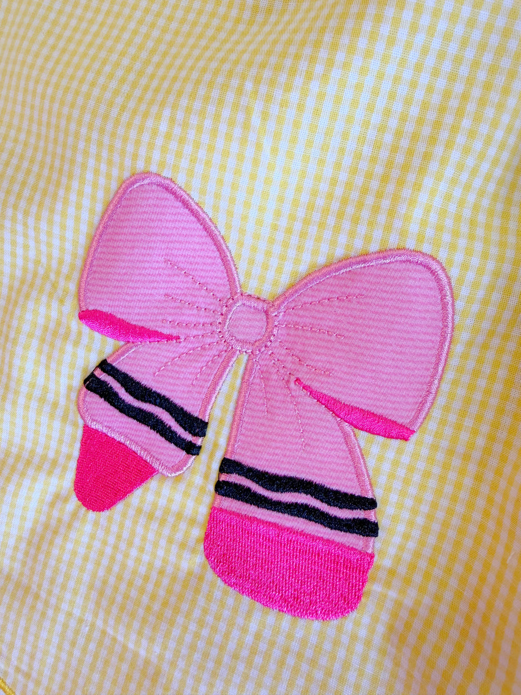Girl’s yellow and pink crayon with pink ribbons on sleeve dress