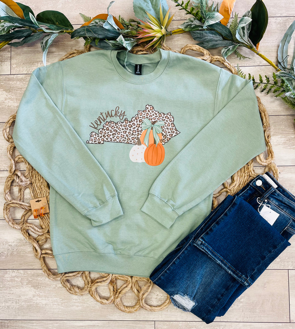 Women’s Sage Green Crewneck Features a cute Leopard - Print outline of Kentucky paired with stacked Autumn Pumpkins