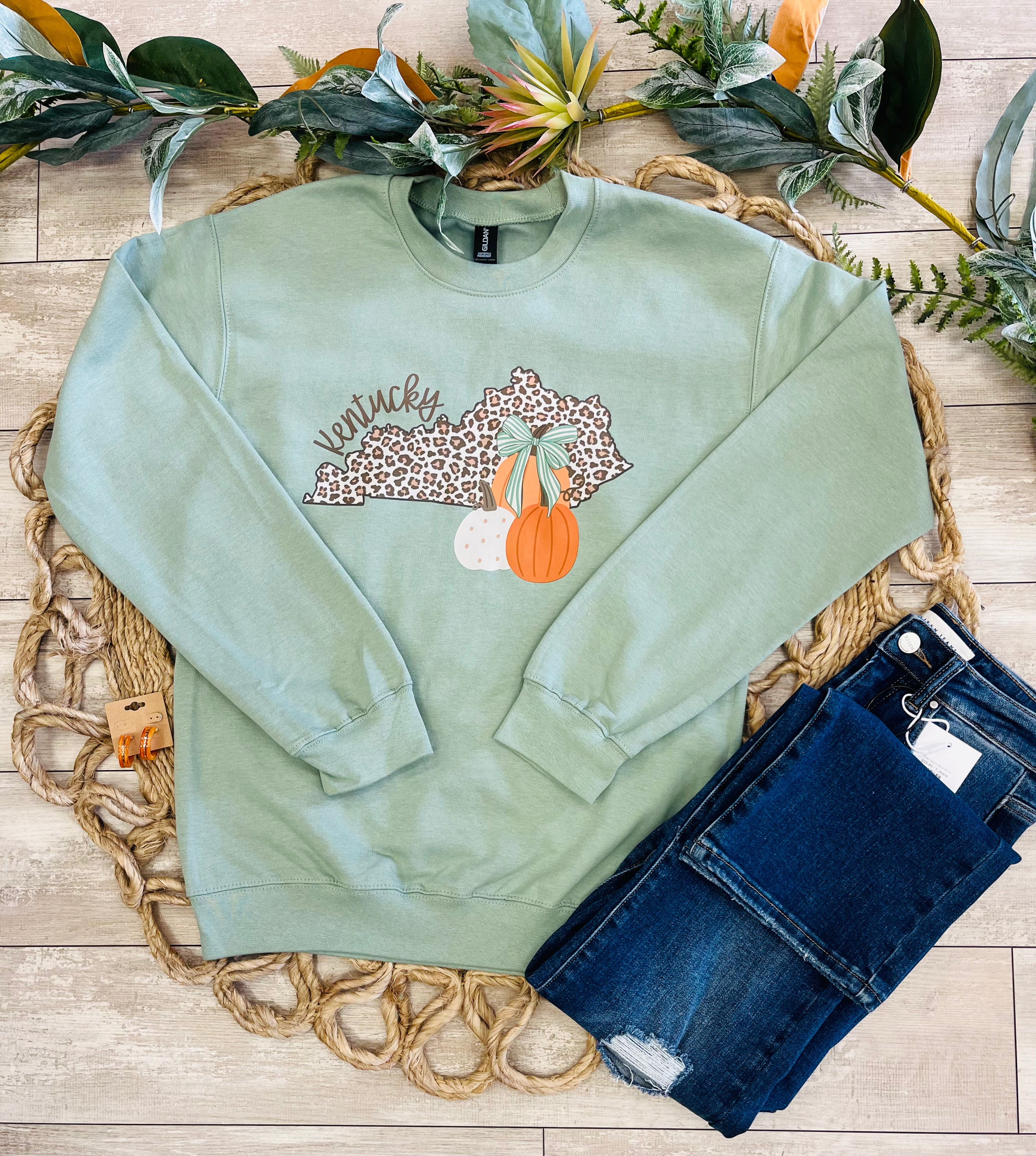Women’s Sage Green Crewneck Features a cute Leopard - Print outline of Kentucky paired with stacked Autumn Pumpkins
