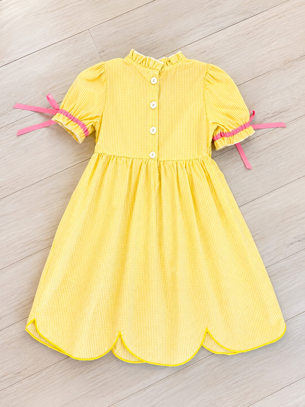 Girl’s yellow and pink crayon with pink ribbons on sleeve dress