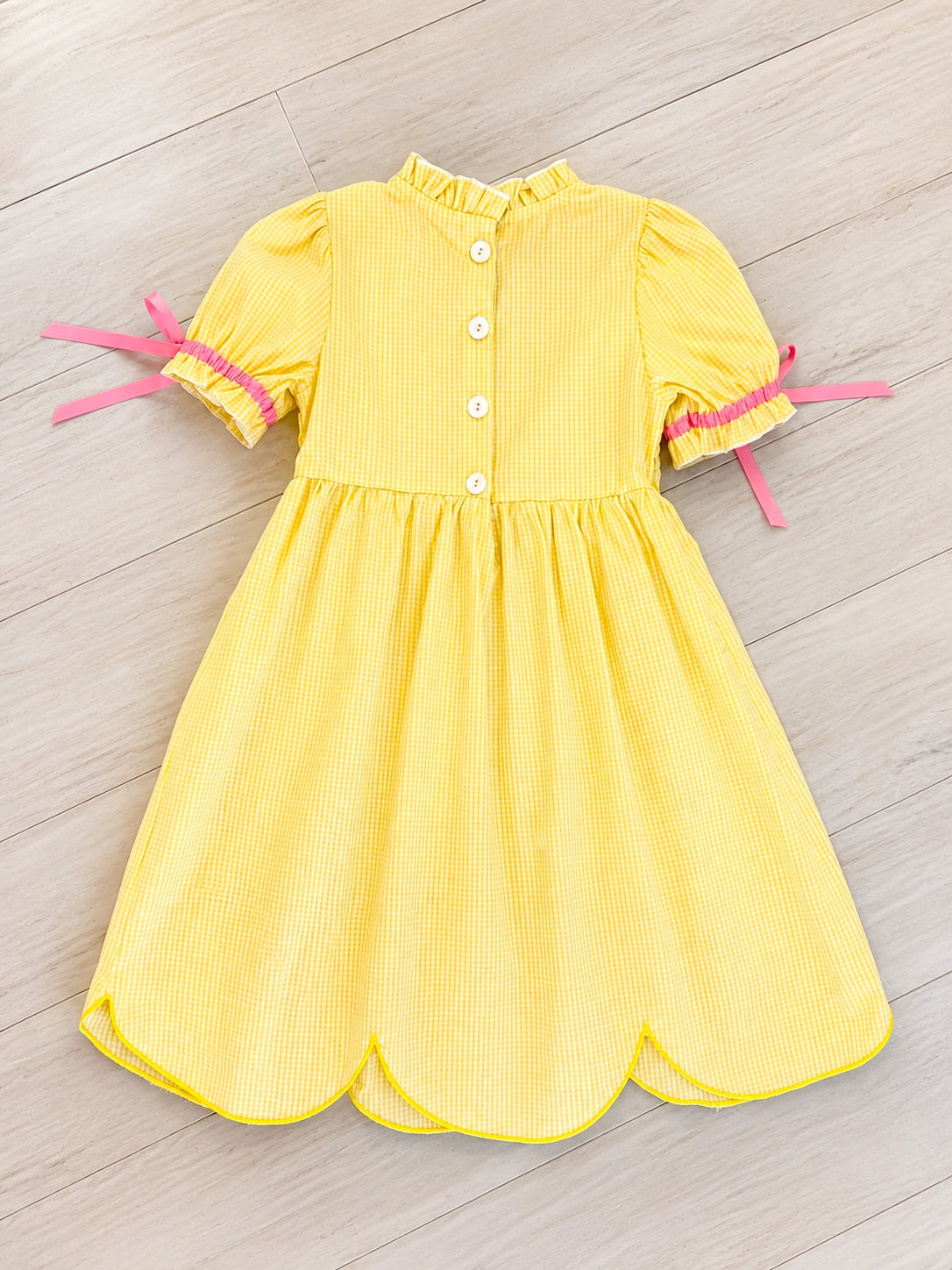 Girl’s yellow and pink crayon with pink ribbons on sleeve dress
